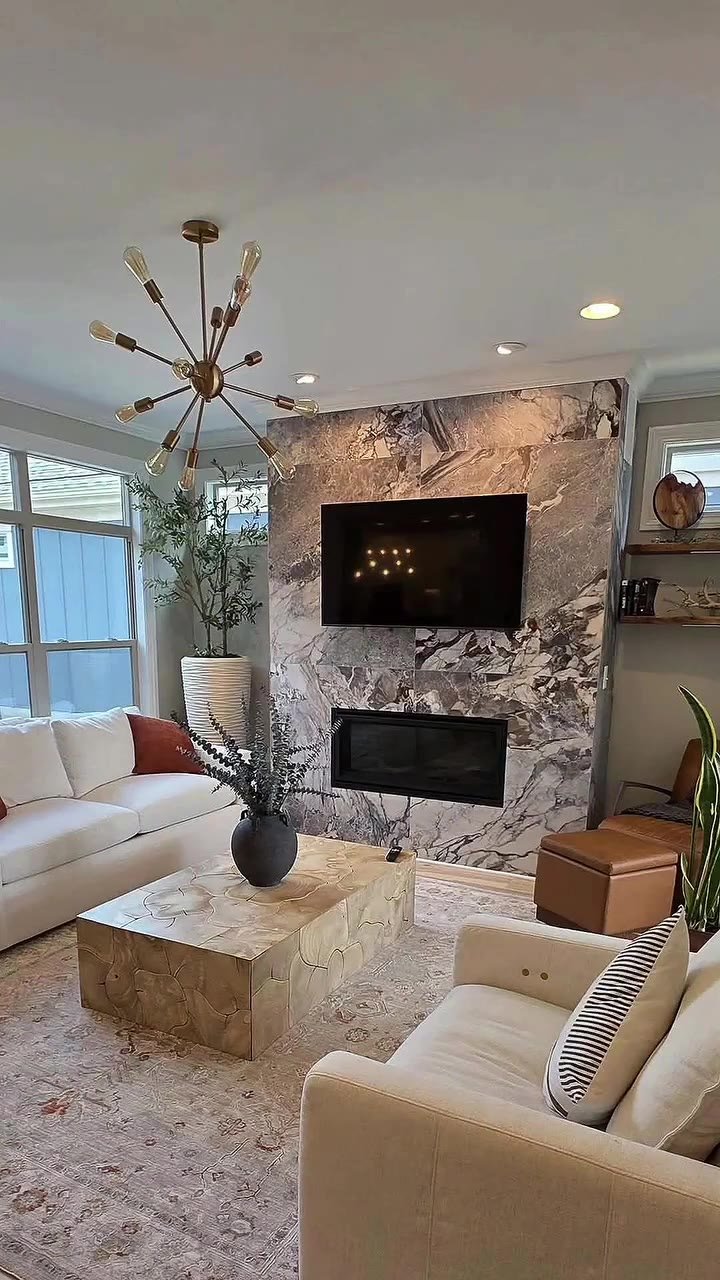 TV mounted on a feature wall above an existing fireplace in a finished living room